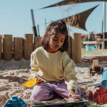A child plays in a kindergarten sandpit