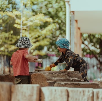 two children playing in an outdoor learning setting