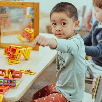 A child plays with shapes in a kindergarten