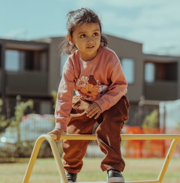 a child plays outdoors at a kindergarten