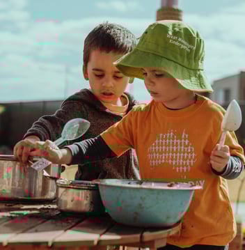 two children playing outdoors at a kindergarten