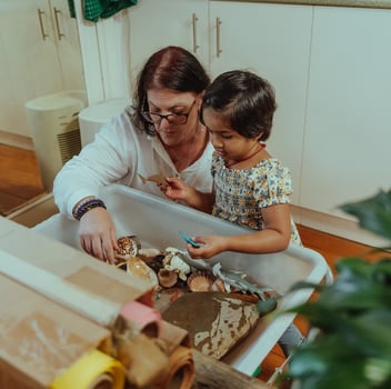An educator helps a child learn in a kindergarten