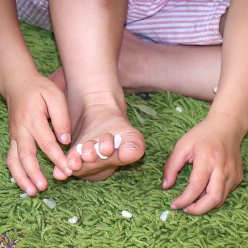 A child with bare feet playing in a kindergarten