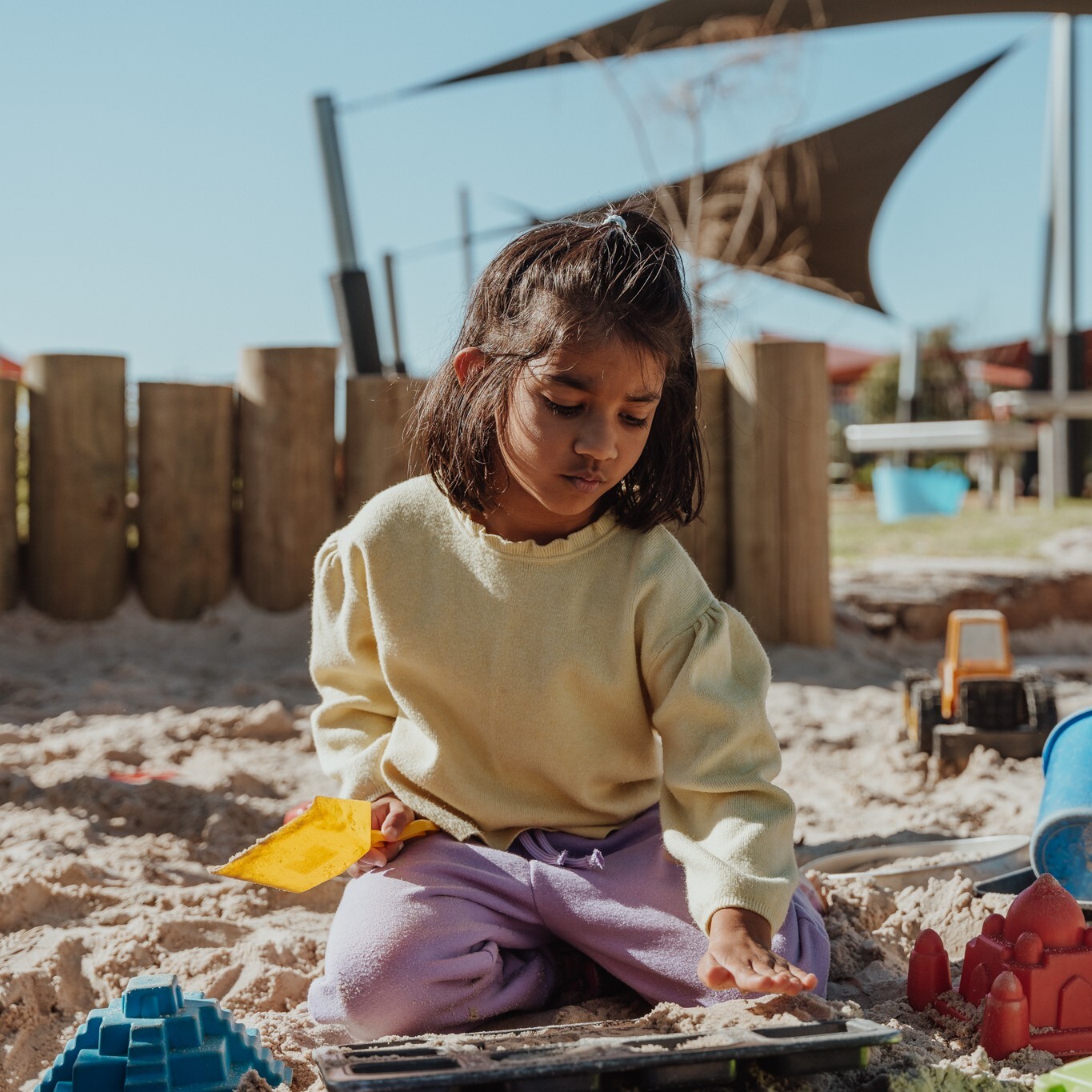 A child plays in a kindergarten sandpit