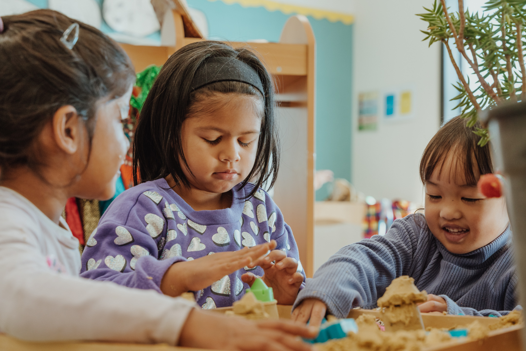 Three children learning through play in a kindergarten
