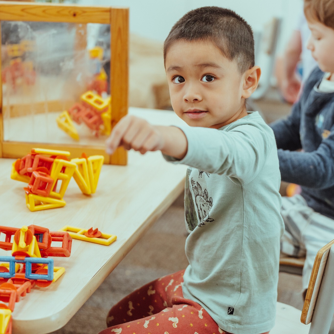 A child plays with shapes in a kindergarten