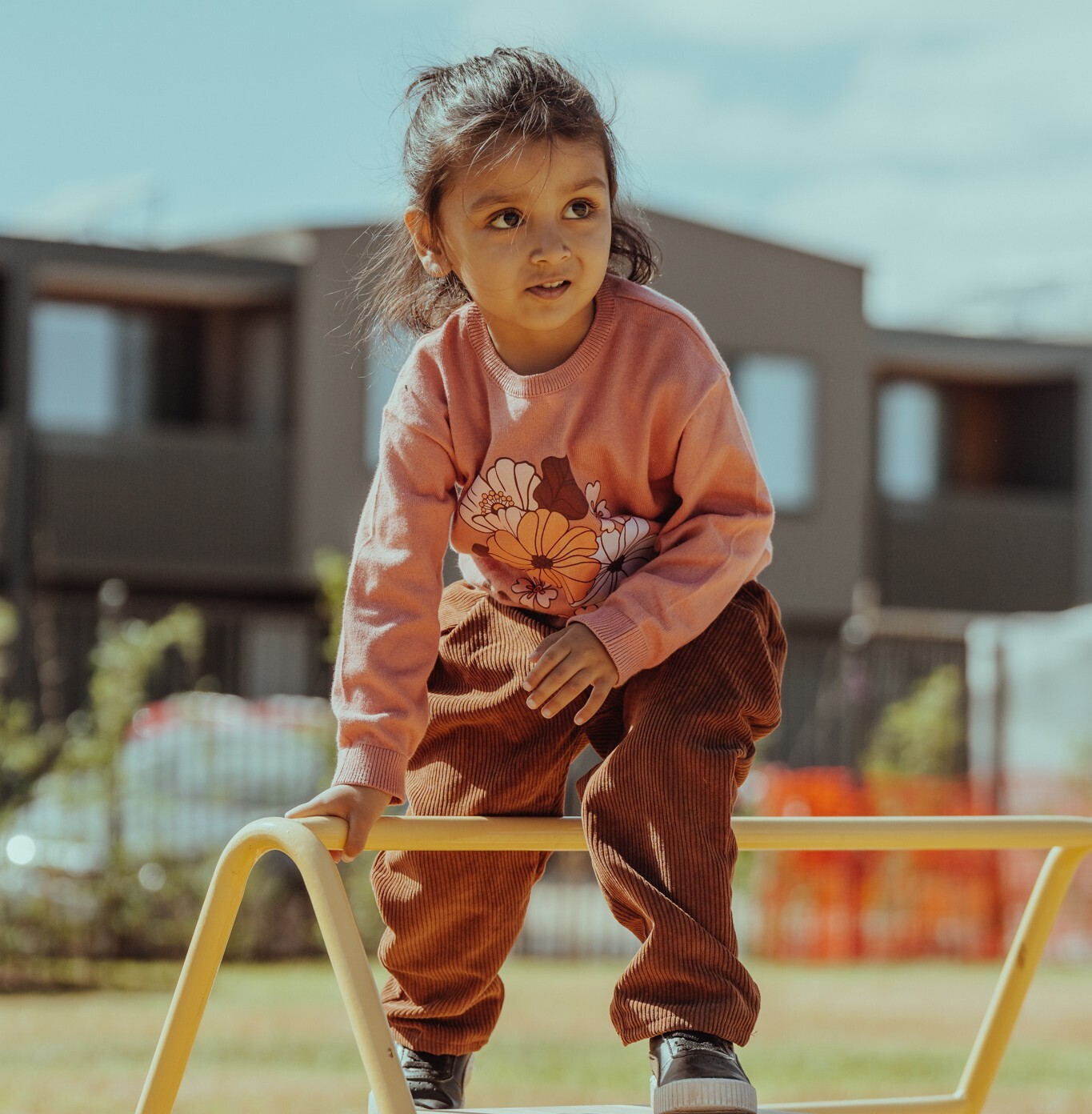 a child plays outdoors at a kindergarten