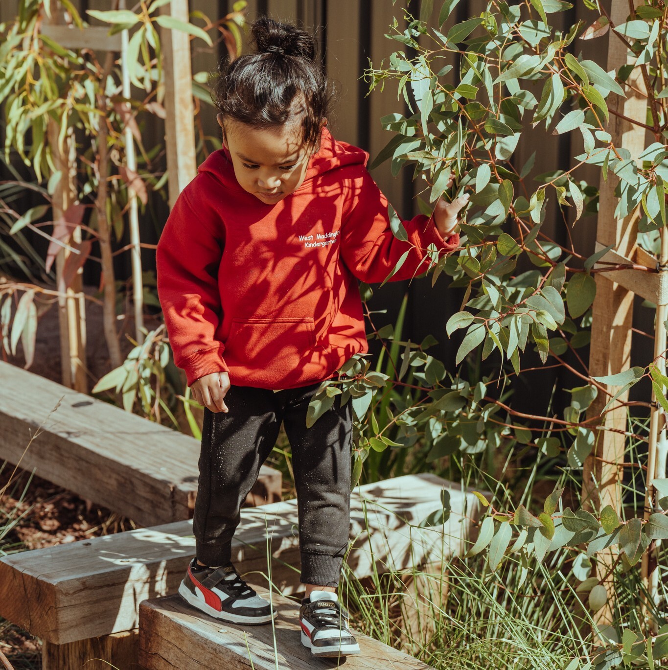 A child plays in an outdoor kindergarten setting