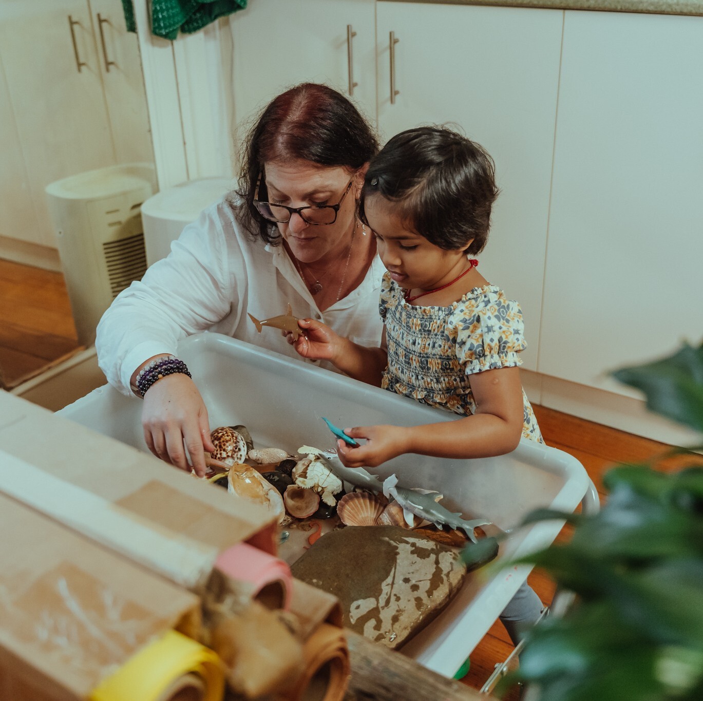 An educator helps a child learn in a kindergarten