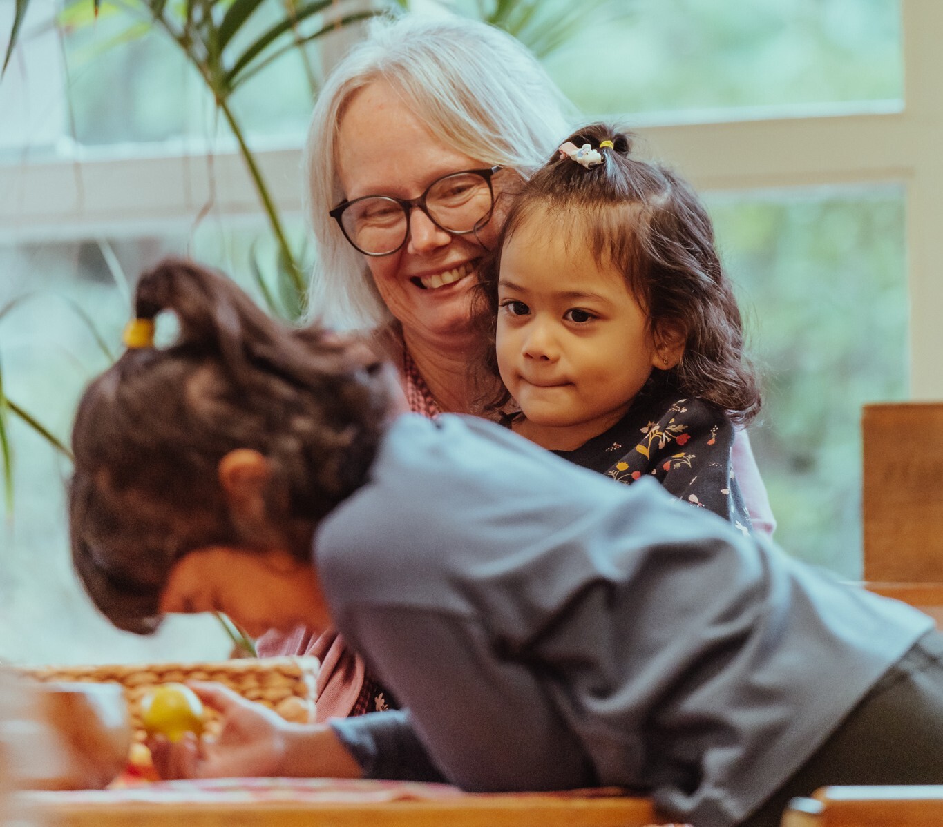 An educator with two children at a kindergarten