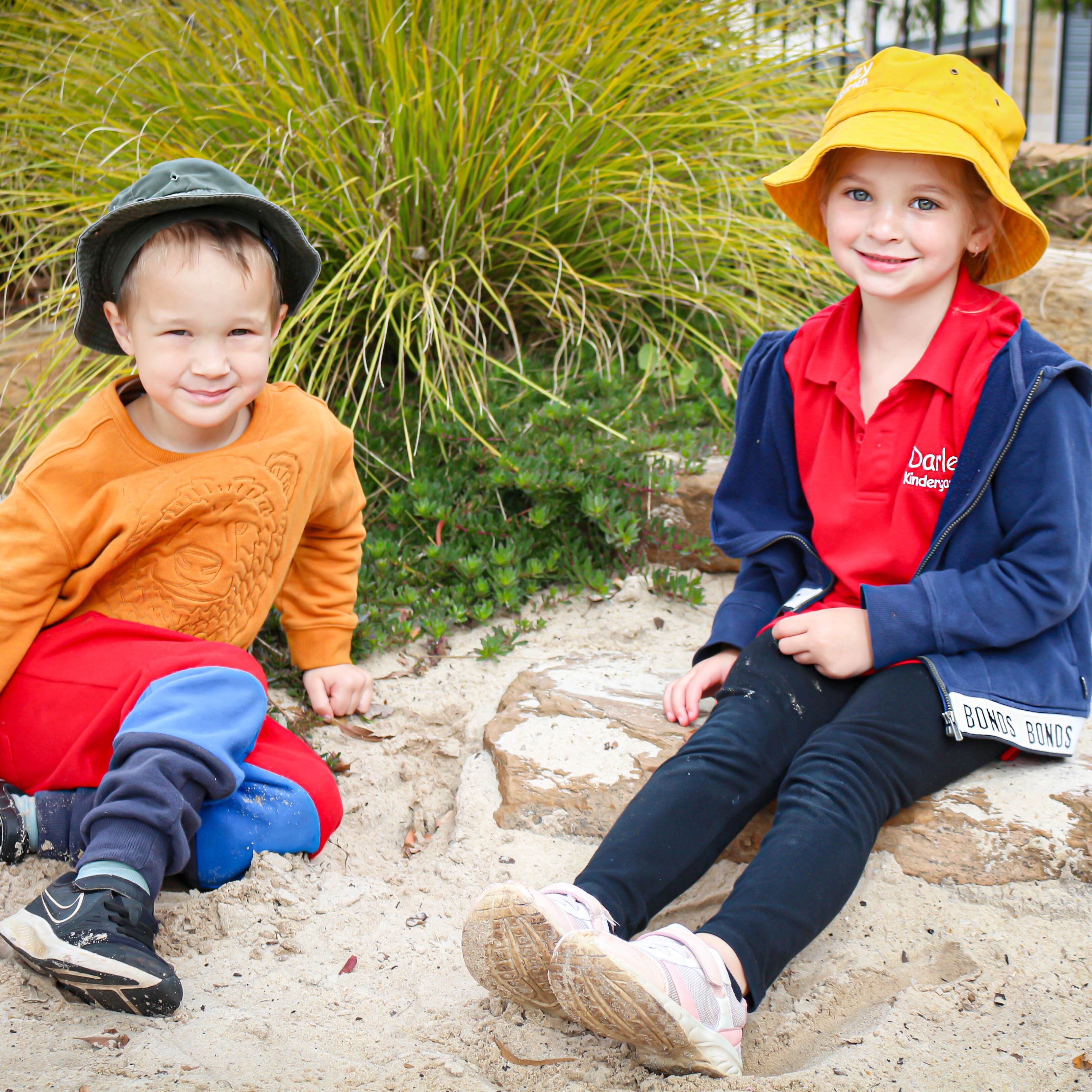 Two children sitting in a kindergarten play area