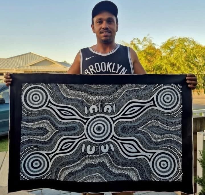 An Aboriginal man showing his painting